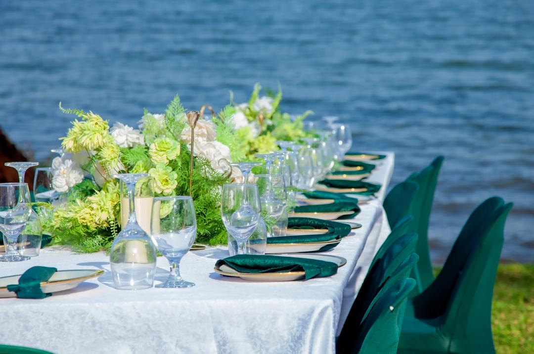 A long dinner table laid beside Lake Victoria at the FOCUS Campsite