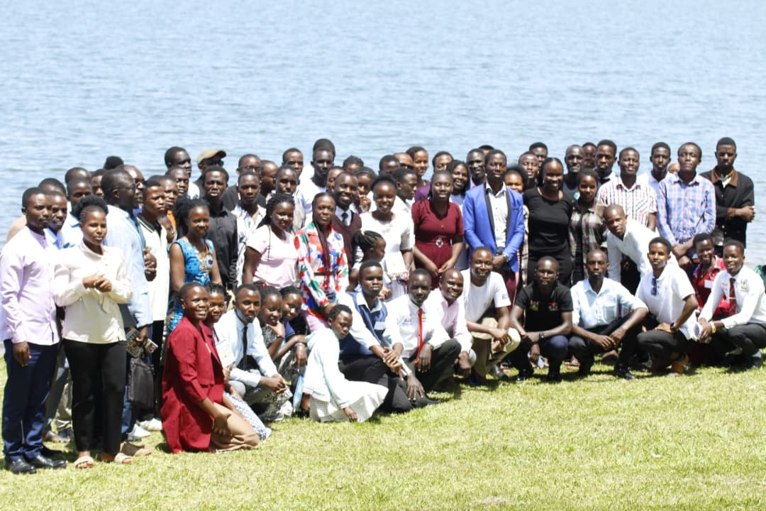 A large conference group photographed on the lawn beside Lake Victoria