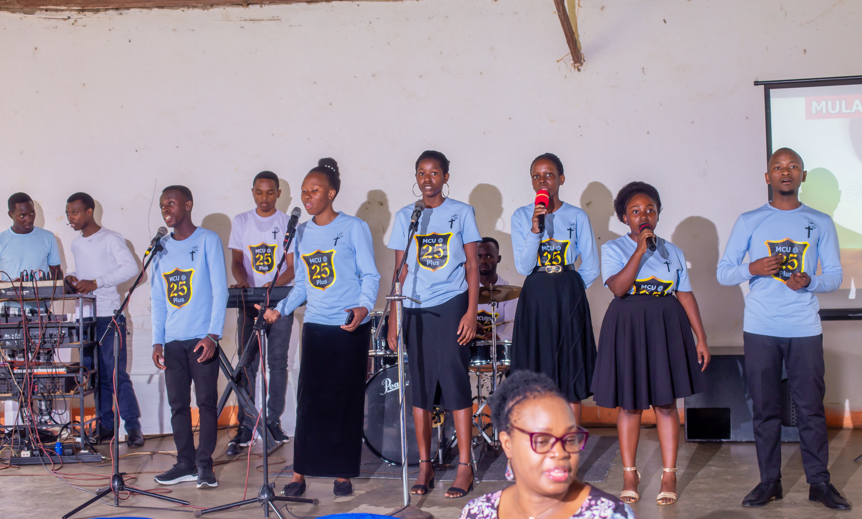 A student choir in FOCUS shirts performing at the Annual General Meeting